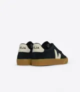 Championes Veja modelo Campo Bold, color negro con logo lateral en forma de "V" color crema, capellada de gamuza, forro interior de poliéster reciclado, plantilla de caucho amazónico y caña de azúcar, y suela de caucho amazónico y sintético.