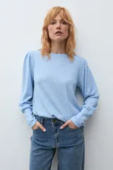 Remera de manga larga con diseño de hombros abullonados y cuello redondo, confeccionada en tejido de punto suave.
