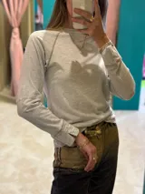 Remera blanca de corte clásico con mangas largas y cuello redondo.