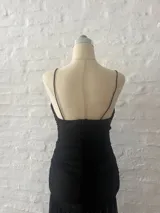 Vestido corto negro de microtul con breteles finos y escote en V.