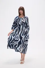 Vestido midi holgado con estampado de hojas en tonos verde y beige, cuello redondo con abertura en V y botones, y mangas 3/4 abullonadas.