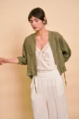 Campera bomber verde militar de lino, con cierre frontal, bolsillos laterales y detalles de cordones ajustables en el ruedo.