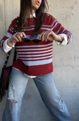 Sweater fluido de punto con diseño de rayas horizontales en color bordó y celeste, de manga larga y cuello redondo.
