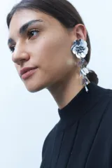 Aros colgantes plateados con forma de flor y lentejuelas colgantes.