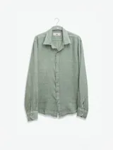 Camisa de manga larga confeccionada 100% en lino, color verde claro, con calce recto y relajado. Presenta frente abotonado con botones de coco con logo y el patch característico de Polonio.