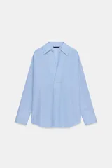 Camisa de manga larga en color celeste con estampado de rayas finas, cuello solapa y escote en pico con detalle de solapa frontal. Presenta puños abotonados y bajo asimétrico.