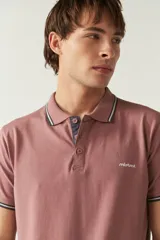 Remera polo color marrón con terminaciones a contratono y logo estampado. Corte regular y mangas cortas. Confeccionada en algodón.