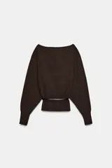 Jersey de punto color mostaza con cuello barco, manga larga con sisa ancha y detalle de cinturón fino integrado en la cintura.