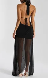 Vestido largo negro con escote halter profundo drapeado y falda larga con transparencias y tajo lateral.