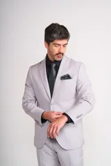 Ambo de ceremonia color verde petróleo, compuesto por saco de dos botones, pantalón de corte recto y chaleco gris con estampado jacquard. Incluye pañuelo de bolsillo y corbatón a juego.