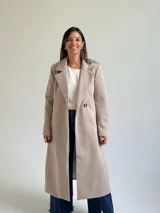 Tapado largo de paño en color beige, con solapas anchas, cierre frontal de un botón y diseño estructurado.