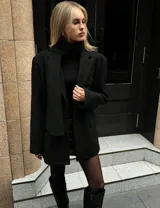 Blazer de corte oversize en color negro, con solapas clásicas, bolsillos laterales con solapa y cierre frontal con botones.