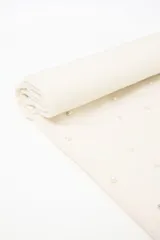 Pashmina de tejido de punto color blanco, decorada con pequeñas perlas dispersas por toda la superficie. Presenta flecos en los extremos y una etiqueta de cuero sintético con logo en una esquina.