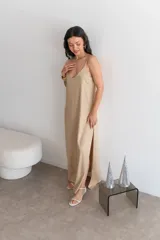 Vestido largo rojo brillante, con escote en V y tirantes finos. Presenta un corte holgado y abertura lateral en la falda.