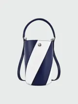 Mini bolso tipo bucket Longchamp de la línea Épure, en combinación de color azul marino y blanco con diseño diagonal. Cuenta con asa corta superior y correa larga para llevar cruzado, además de cierre con botón a presión metálico.