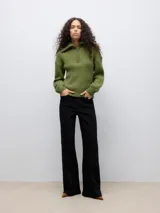 Sweater de punto acanalado color verde oliva, con cuello alto, cierre frontal parcial y mangas largas. Presenta un diseño de calce regular con puños y ruedo acanalados.