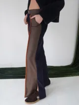 Pantalón de paño combinado con tira de cuero color marrón.