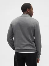 Buzo de tejido de punto color negro, con cuello alto y cierre frontal parcial. Presenta puños y ruedo acanalados.