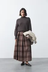 Polera de tejido de punto en color marrón oscuro, con cuello alto y diseño de silueta relajada.