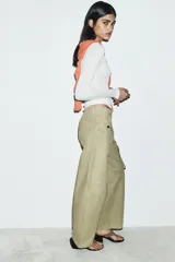 Pantalón cargo de tiro medio confeccionado en algodón, con diseño de pierna ancha, cintura con trabillas, bolsillos delanteros y bolsillos de plastrón con solapa en la pierna.