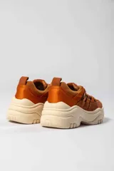 Championes de caña baja color marrón, con detalles en naranja y suela chunky color crema.