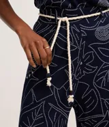 Pantalón recto color azul marino con estampa de follaje en blanco, confeccionado en viscosa con textura acanalada. Incluye trabillas en la cintura y un cinturón tipo cuerda.