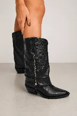 Bota de estilo western confeccionada en cuero genuino negro con textura rugosa. Presenta un diseño de caña alta con costuras decorativas en relieve, cierre lateral metálico y taco cuadrado de 4 cm.
