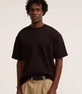 Remera de corte boxy con cuello redondo y mangas cortas, confeccionada en malla pesada con textura gomosa.