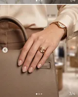 Anillo de acero con baño de oro, compuesto por tres bandas entrelazadas, decorado con tres pequeñas circonias engastadas.