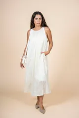 Vestido midi de corte amplio y silueta recta, con cuello redondo y diseño sin mangas. Confeccionado en tejido ligero de textura sutil, cuenta con bolsillos laterales.