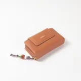 Billetera Belladria de cuero sintético marrón, con solapa frontal, cierre de cremallera y detalle de tirador con cuentas de colores y aplique metálico con el logo de la marca.