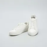 Zapatillas bajas blancas de cuero sintético con cordones y detalle en color beige en el talón.