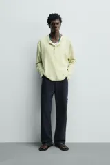 Pantalón cargo straight fit de algodón color negro con efecto lavado, bolsillos laterales en las piernas y cierre frontal con cremallera y botón.