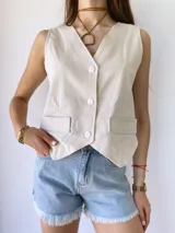 Colgante con cordón de cuero color camel y dije metálico dorado con forma de estribo.