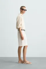 Bermuda de corte regular fit, color blanco hueso, confeccionada en tejido de algodón y lino. Presenta pliegues frontales, bolsillos delanteros y bolsillos traseros de plastrón.