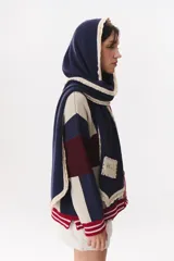 Bufanda de punto color marrón con capucha integrada y bordes en color crema. Presenta una etiqueta rectangular bordada con la palabra Anthea en uno de sus extremos.