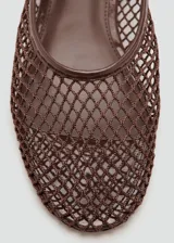 Zapato plano estilo Mary Jane color marrón, confeccionado con tejido de malla tipo red con diseño de rejilla. Cuenta con punta redondeada, suela plana y tira ajustable con hebilla metálica en el tobillo.