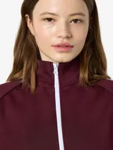 Campera deportiva de cuello alto con cierre frontal completo, mangas largas raglán con franjas laterales blancas en contraste y puños elásticos.