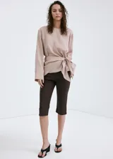 Pantalón capri de corte recto y color marrón, confeccionado en mezcla de lino y algodón con forro interior de algodón.