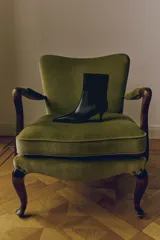 Botines de caña media con punta fina y taco fino tipo kitten heel. Presentan un diseño minimalista con costuras laterales visibles y cierre lateral.