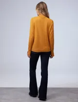 Polera de tejido fino, color rosado, con cuello alto, manga larga y detalle de tajo en los puños.