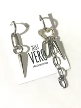 Par de aros colgantes asimétricos de acero quirúrgico color plateado. Uno con cierre tipo anzuelo y cadena de eslabones con dije de pincho. El otro con cierre a presión, dije de corazón, cadena de eslabones y dije de pincho.