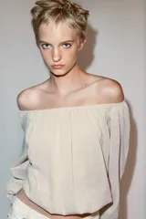 Blusa de punto color beige con cuello barco, manga larga abullonada con puños ajustados y detalles fruncidos en la parte delantera.