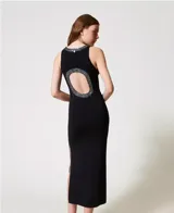 Vestido largo negro de tejido de punto con cuello redondo y espalda descubierta con borde de lentejuelas. Tiene tirantes anchos, abertura lateral y corte ajustado.