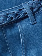 Pantalón de jean azul de pierna ancha con cinturón trenzado.