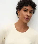 Blusa de manga larga con cuello redondo, confeccionada en una mezcla de algodón y elastano. Presenta un diseño básico, ajustado y liso, ideal para uso diario.