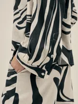 Pantalón ancho con estampado floral en tonos verde y blanco, con pinzas en el frente, bolsillos laterales y elástico en la cintura.