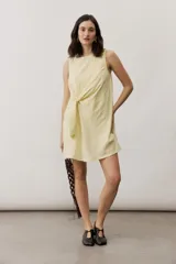 Vestido corto blanco sin mangas, con cuello redondo y detalle de nudo drapeado en el lateral.