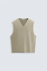 Chaleco de punto color beige claro, con cuello en V y corte relajado sin mangas.