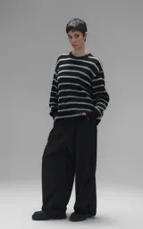 Sweater de cuello redondo con diseño de rayas horizontales en negro y gris. Presenta una textura suave y peluda, con terminaciones en punto rib en el cuello.